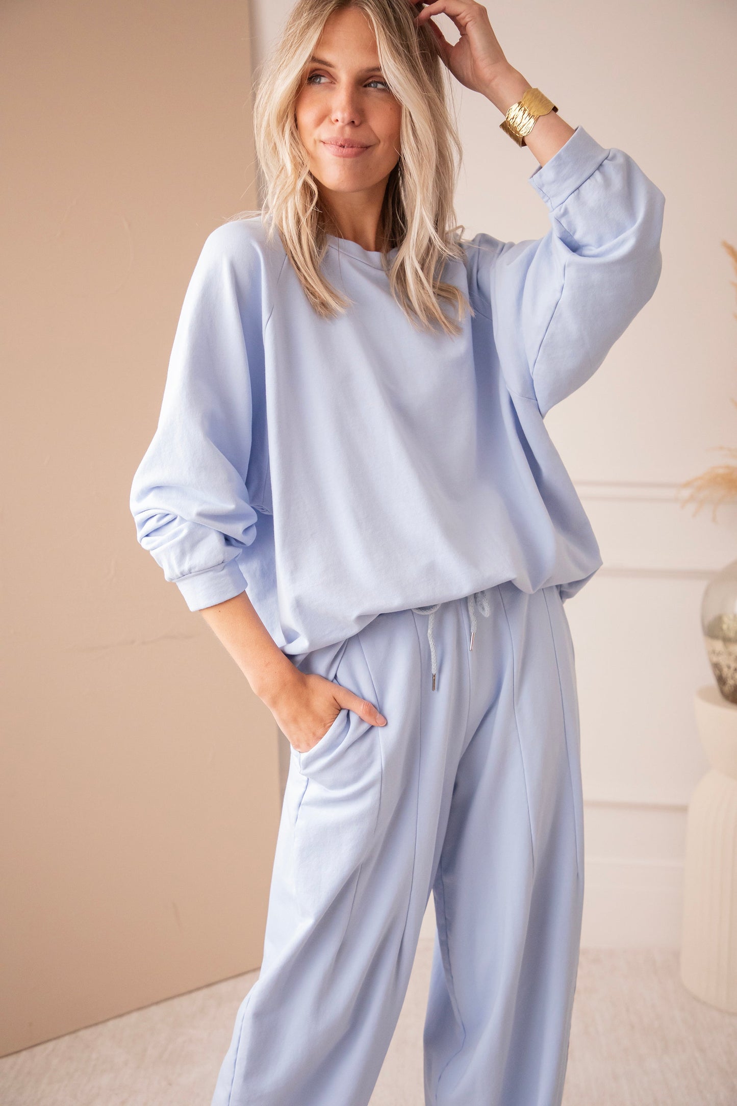 Detail světle modré oversized mikiny s dlouhými rukávy
